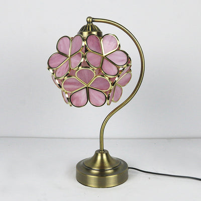 Table lamp with pink floral glass shade on a white background